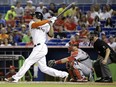 In this Aug. 11, 2014, file photo, Miami Marlins' Giancarlo Stanton, left, watches his two-run home run against the St. Louis Cardinals. Stanton has agreed to terms with the Marlins on a $325-million, 13-year contract, Monday, Nov. 17, 2014.