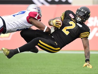 Hamilton Tiger-Cats Nic Grigsby flies into the end zone for a touchdown past Montreal Alouettes cornerback Billy Parker during first half action in the CFL Eastern Division final in Hamilton, Ont., on Sunday, Nov. 23, 2014.