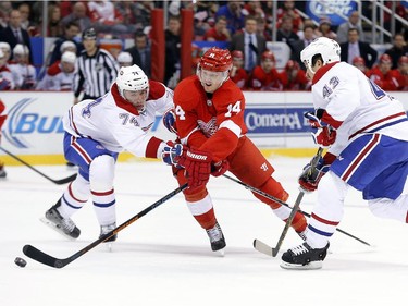 Detroit Red Wings center Gustav Nyquist (14) skates against Montreal Canadiens defenseman Alexei Emelin (74) and defenseman Mike Weaver (43) in the first period of an NHL hockey game in Detroit, Sunday, Nov. 16, 2014.