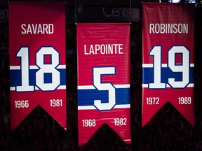 Former Canadien Guy Lapointe's No. 4 is raised alongside Serge Savard's No. 18 and Larry Robinson's No. 19 during ceremony before game at the Bell Centre on Nov. 8, 2014.