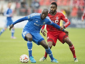 The Impact's Hassoun Camara, left, protects the ball from Toronto FC's Warren Creavalle during MLS action in Toronto on Oct. 18, 2014.