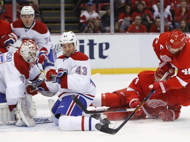 Detroit Red Wings left wing Henrik Zetterberg (40) tries to shoot as he falls as Montreal Canadiens defenseman Mike Weaver (43) defends with goalie Dustin Tokarski (35) in the first period of an NHL hockey game in Detroit, Sunday, Nov. 16, 2014.