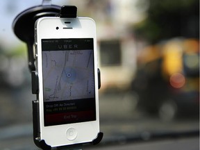 A smartphone is mounted on the glass of an Uber car.