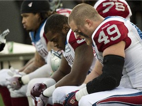 The Alouettes' Jeffrey Finley (49) and his teammates hang their heads during the final minutes of loss to the Tiger-Cats in the CFL East Division final on Nov. 23, 2014 in Hamilton.
