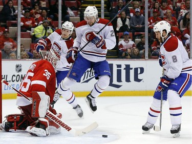 Montreal Canadiens left wing Jiri Sekac (26) jumps to make room for a Brandon Prust (8) shot as Detroit Red Wings goalie Jimmy Howard (35) defends in the second period of an NHL hockey game in Detroit Sunday, Nov. 16, 2014.