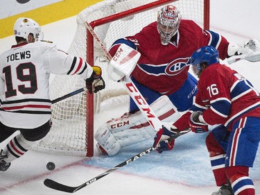 Montreal Canadiens' P.K. Subban defends as Chicago Blackhawks' Jonathan Toews moves in on Canadiens goaltender Carey Price during second-period action in Montreal, Tuesday, Nov. 4, 2014.