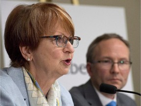 Lucienne Robillard, left, speaks at a news conference announcing her nomination as the head of a commission that will study provincial programs, Wednesday, June 11, 2014 in Quebec City. Quebec Treasury Board President Martin Coiteux looks on. Robillard says the province is living beyond its means and needs to find a way to deliver services at a lower cost.