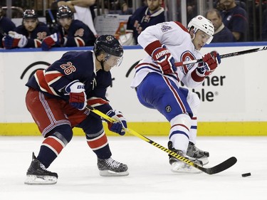 New York Rangers' Martin St. Louis, left, steals the puck from Montreal Canadiens' Alexei Emelin just before scoring during the second period of the NHL hockey game, Sunday, Nov. 23, 2014, in New York.