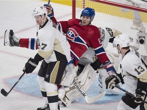 Max Pacioretty falls onto Pittsburgh Penguins goalie Marc-Andre Fleury during second-period action Tuesday, Nov. 18, 2014, in Montreal.