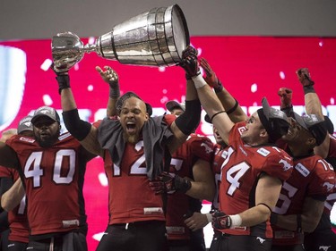 Members of the Calgary Stampeders hoist the Grey Cup as they celebrate after defeating the Hamilton Tiger-Cats in the 102nd Grey Cup in Vancouver, B.C. Sunday, Nov. 30, 2014.