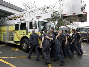 Members of the Hudson Fire department push their new ladder truck into the firehouse in an innauguration ceremony April 29, 2007.