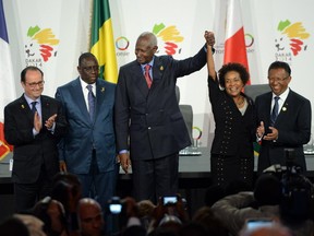 President of France Francois Hollande, left, President of Sénégal Macky Sall, second from left and President of Madagascar Hery Rajaonarimampianina, right, look on as Secretary-General of La Francophonie Abdou Diouf raises the hand of former governor general Michaelle Jean as she celebrates after being chosen as the new Secretary-General of La Francophonie during the Francophonie Summit in Dakar, Sénégal on Sunday, November 30, 2014.