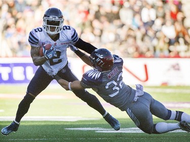Toronto Argonauts' Chad Owens, left, is tackled by Montreal Alouettes' Mitchell White during second half CFL football action in Montreal, Sunday, November 2, 2014.