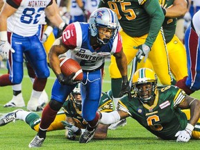 Alouettes running-back Brandon Whitaker breaks away from Eskimos defenders during a CFL game at Edmonton's Commonwealth Stadium on Sept. 12, 2014.