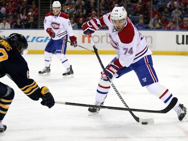 Montreal Canadiens' Alexei Emelin passes the puck up ice past Buffalo Sabres' Tyler Ennis during the first period on Wednesday, Nov. 5, 2014, in Buffalo, N.Y.