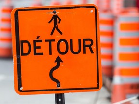 A detour sign amid construction cones.