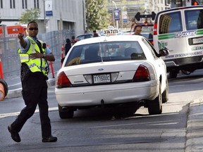 A police officer directs a motorist to pull over after he made an illegal left turn onto Ontario St. from St-Laurent Blvd. Monday, August 24, 2009 in Montreal.