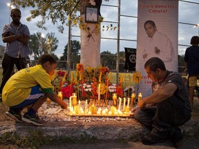 Gilberto Villanueva, (right) Fredy Villanueva's father, lights candles  at a vigil commemorating the 5th anniversary of the shooting of her son in Montreal-North area of  Montreal Friday Aug. 9, 2013.