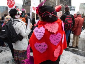 A woman wears messages on her back at a rally at Victoria Square in Thursday, February 14, 2013 on a day when a supermodel who campaigned against rape and for women's rights was shot dead in South Africa while a trial of five men accused of keeping a woman in sexual slavery continues in Montreal.