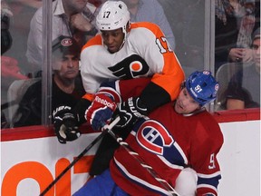 The Canadiens' David Desharnais checks the Philadelphia Flyers' Wayne Simmonds into the boards during game at the Bell Centre on Feb. 16, 2013.
