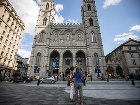 Tourists take photographs of the Notre-Dame Cathedral in Old Port in Montreal on Tuesday, July 30, 2013.