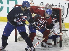 Canadiens forward David Desharnais (middle) battles with defenceman Jarred Tinordi in front of goalie Carey Price during practice at the Bell Sports Complex in Brossard on Nov. 3, 2014.