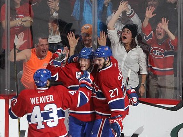 Fans celebrate goal by Montreal Canadiens right wing Brendan Gallagher, centre, with his teammates Montreal Canadiens' Mike Weaver (43) and Montreal Canadiens' Alex Galchenyuk, right,  during second period NHL action in Montreal on Saturday November 08, 2014.