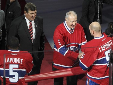 Guy Lapointe, centre,  shakes hand with Montreal Canadiens' Andrei Markov, right, with P.K. Subban in front of  Serge Savard, red tie, and Larry Robinson, during the retirement of Lapointe's number at the Bell centre  in Montreal on Saturday November 08, 2014.