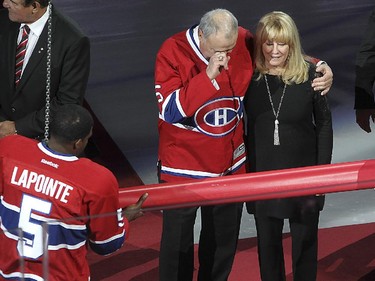 Guy Lapointe, wipes away a tear next to his wife, Louise, as  Montreal Canadiens' Andrei Markov, right, and  P.K. Subban bring out flag with number 5,  during the retirement of Lapointe's number at the Bell centre  in Montreal on Saturday November 08, 2014.