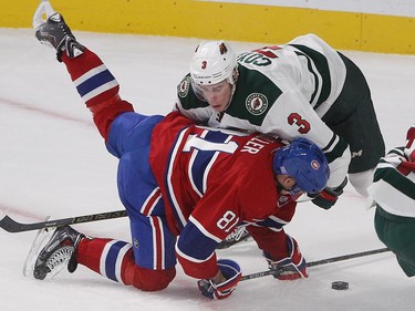 Minnesota Wild center Charlie Coyle (3) brings down Montreal Canadiens' Lars Eller during second period NHL action in Montreal on Saturday November 08, 2014.