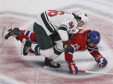 Montreal Canadiens defenseman Andrei Markov, right, brings down Minnesota Wild left wing Erik Haula during first period NHL action in Montreal on Saturday November 08, 2014. Markov got penalty on the play.