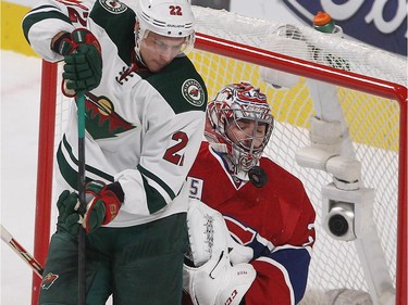 Montreal Canadiens goalie Carey Price follows puck passing next to his mask with Minnesota Wild right wing Nino Niederreiter next to Price, during first period NHL action in Montreal on Saturday November 08, 2014.