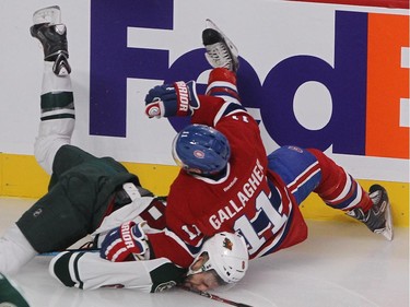 Montreal Canadiens right wing Brendan Gallagher falls on Minnesota Wild defenseman Marco Scandella, after colliding in the boards during first period NHL action in Montreal on Saturday November 08, 2014.