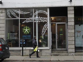 A pedestrian passes in front of Santé Cannabis. The clinic opens its doors officially on Tuesday, Nov. 11, 2014 in Montreal. It's the first and perhaps the only medical clinic specializing in medical pot. Here is where patients can go for an evaluation for a marijuana prescription.