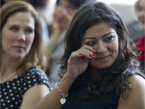 Ursula, who doesn't want her last name used, wipes away tears during a news conference in Laval, north of Montreal, Monday, November 10, 2014, after she spoke about her experience of psychological abuse.  Three women's shelters launched a campaign to bring awareness to the issue of conjugal violence and psychological abuse.  Looking on is Pascale Bouchard, director of Maison Le Prélude, one of the three shelters which organized the campaign.