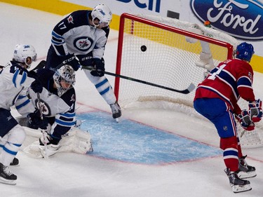 Lars Eller scores on Jets goalie Ondrej Pavelec as left wing Adam Lowry, top, and centre Mathieu Perreault look on during at the Bell Centre on Tuesday, Nov. 11, 2014.