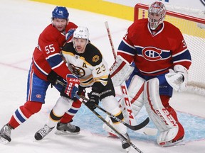 Sergei Gonchar of the Montreal Canadiens and Chris Kelly of the Boston Bruins battle in front of goalie Carey Price in the first period of an NHL game Thursday, November 13, 2014, at the Bell Centre in Montreal.