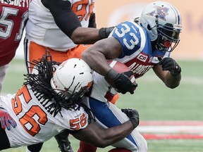 B.C. Lions linebacker Solomon Elimimian, left, tackles Montreal Alouettes running back Brandon Rutley, right, during the first half of their CFL East Division semifinal at Molson Stadium in Montreal on Sunday, November 16, 2014.