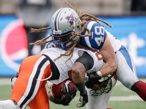 Montreal Alouettes linebacker Bear Woods, right, tackles B.C. Lions running back Stefan Logan, left, during the first half of their CFL East Division semifinal at Molson Stadium in Montreal on Sunday, November 16, 2014.