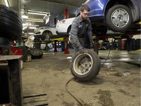 Merson Automotive mechanic Tyler Delisi changes winter tires for clients at the garage in N.D.G., Tuesday November 18, 2014.