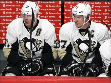 Pittsburgh Penguins Evgeni Malkin, left, and Sidney Crosby watch the action from the bench during National Hockey League game against the Canadiens in Montreal Tuesday November 18, 2014.