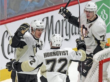 Pittsburgh Penguins Sidney Crosby celebrates his second period power-play goal with team-mates Evgeni Malkin, rear, and Patric Hornqvist during National Hockey League game against the Canadiens in Montreal Tuesday November 18, 2014.