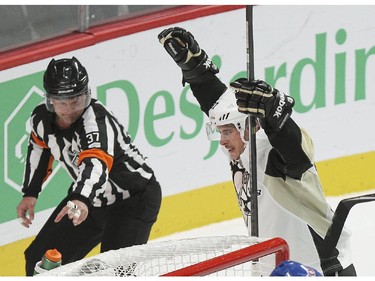 Referee Kyle Rehman points to the puck in the net as Pittsburgh Penguins Sidney Crosby celebrates his second period power-play goal during National Hockey League game against the Canadiens in Montreal Tuesday November 18, 2014.