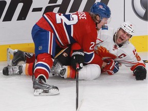 Dale Weise of the Montreal Canadiens knocks down Mark Giordano of  the Calgary Flames in the third period of an NHL game at the Bell Centre on Sunday.