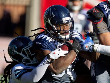 Montreal Alouettes James Rodgers, right gets dragged down by Toronto Argonauts defensive back Alex Suber during CFL action at the Molson Stadium in Montreal on Sunday November 2, 2014.  Toronto Argonauts defensive back Matthew Ware also has a hand on Rodgers.