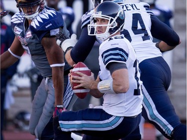 Toronto Argonauts quarterback Ricky Ray, centre, looks for an opening against the Montreal Alouettes during CFL action at the Molson Stadium in Montreal on Sunday November 2, 2014.  Montreal Alouettes defensive end John Bowman, left, sacked Ray and Ray left the game injured.