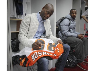 Montreal Alouettes reciever Chad Johnson signs a Cincinnati Bengals jersey for a team-mate as the team cleaned out their lockers at the Olympic Stadium in Montreal Monday November 24, 2014 one day after ending their season with a loss to Hamilton in the CFL Eastern Final.  Johnson, once known as Ochocinco, played in Cincinnati during his NFL career.