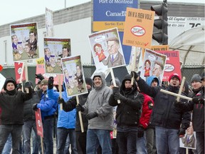 Members of the Montreal city firefighters' union wave at traffic as they block an entrance to the Port of Montreal in 2014.