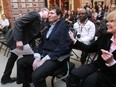 Former McGill  Redmen and Alouettes running back Michael Soles, who is battling ALS, gets a kiss from one of his sons, Anthony,  during a news conference on Nov. 27, 2014. On the right is Jane Soles, Michael's mother.