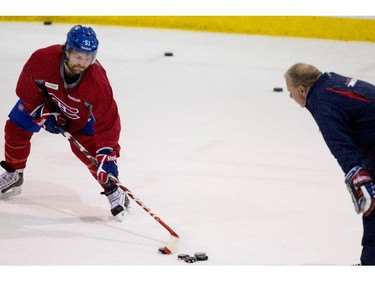 Montreal Canadiens coach Michel Therrien, right, watches closely on Thursday November 27, 2014  as Montreal Canadiens center David Desharnais takes extra shots on net during a team practice at the Bell Sports Complex.